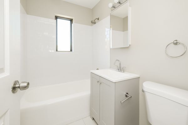 Bathroom with full bathtub and vanity