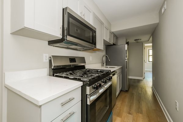 Kitchen with stainless steel appliances, gas range, dishwasher, and white quartz counters